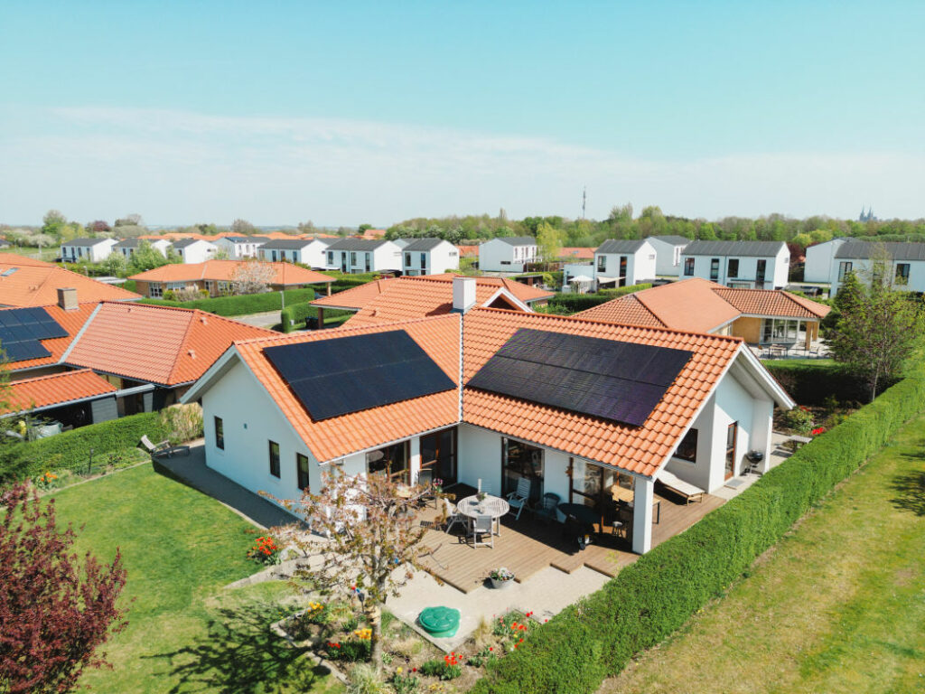 Hus med solceller på taget mens solen skinner